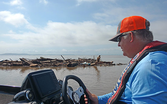 Pete Gluszek of Bass University checks out the floating debris caused by flash flooding on the Chesapeake after the Elite Event was cancelled there last week.&nbsp;